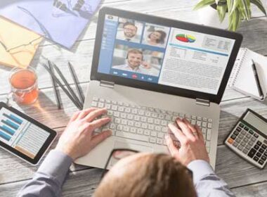 A person sitting at a laptop looking at information about a virtual event.